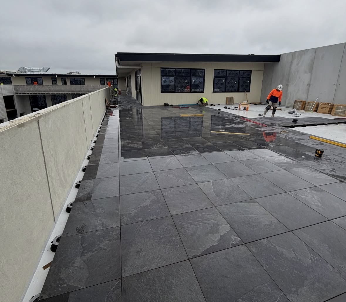 Podium & External Surface Works: Waterproofing, screeding and paving across a large external podium and balcony structure.
