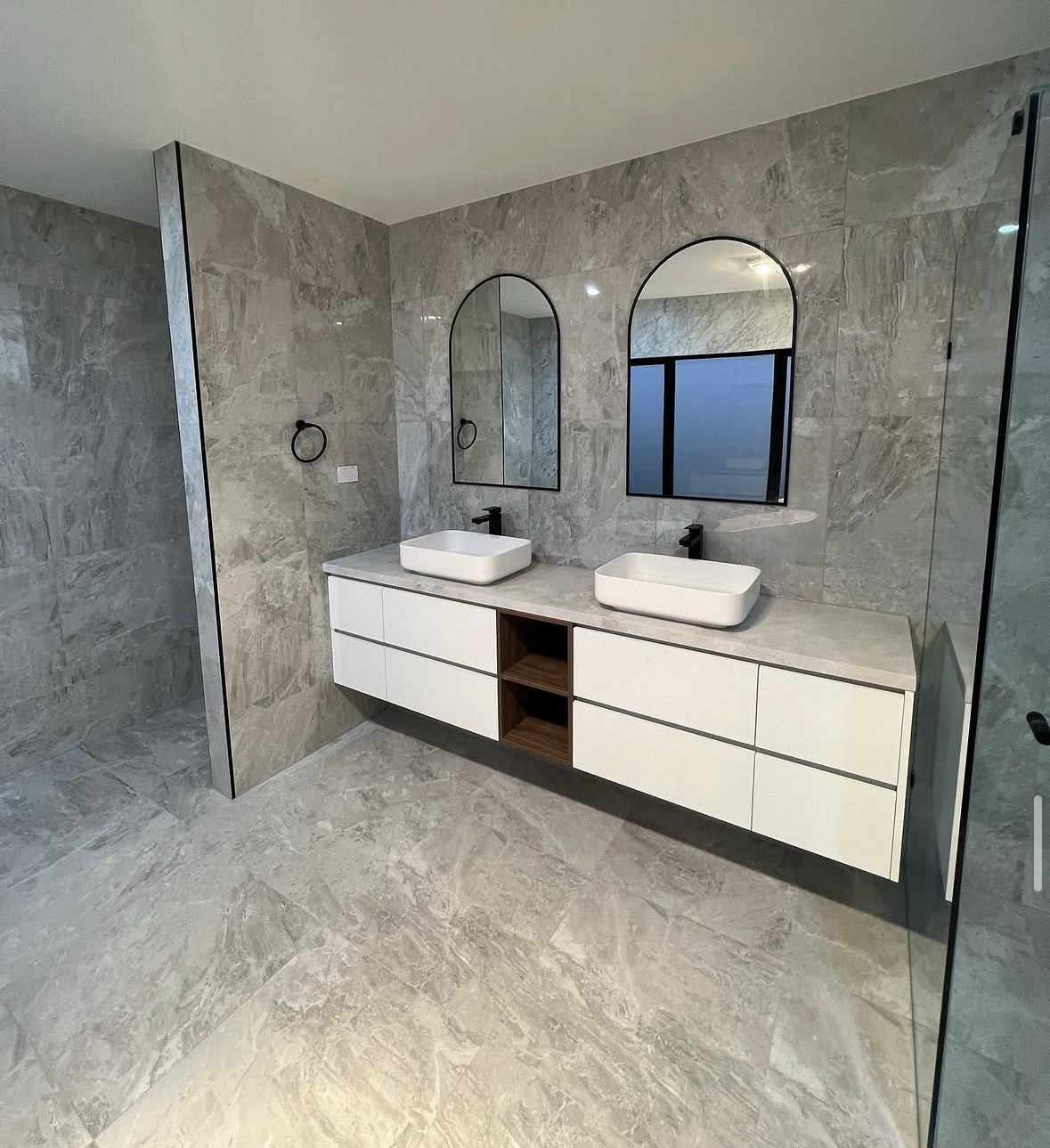 Premium Residential Bathroom: A high-end bathroom renovation with a double vanity and freestanding bath, finished in large-format stone-look tiling.