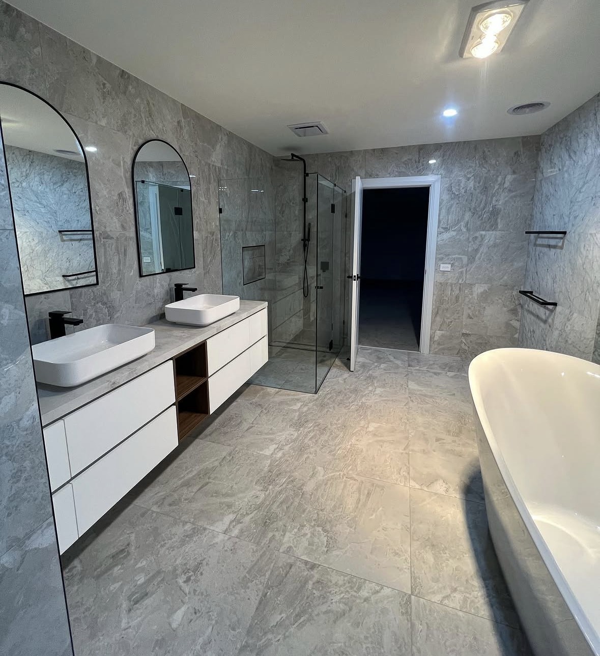 Large-format stone-look surfaces and detailed junctions in a residential bathroom