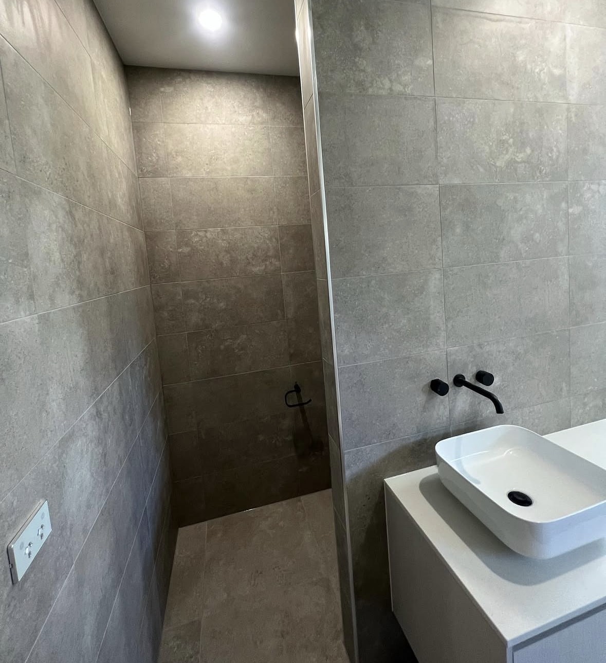 Residential Wet Area Renewal: A full wet-area renewal across a residential bathroom, finished in a dark, premium palette.